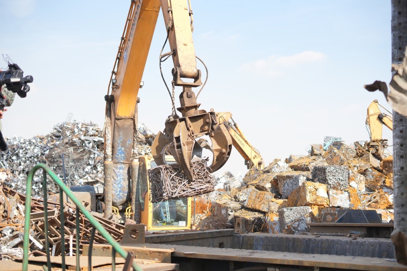 Endüstriyel hurda sahasında metal balyalarını taşıyan vinç